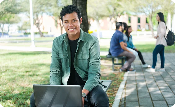 Boy with computer in the park