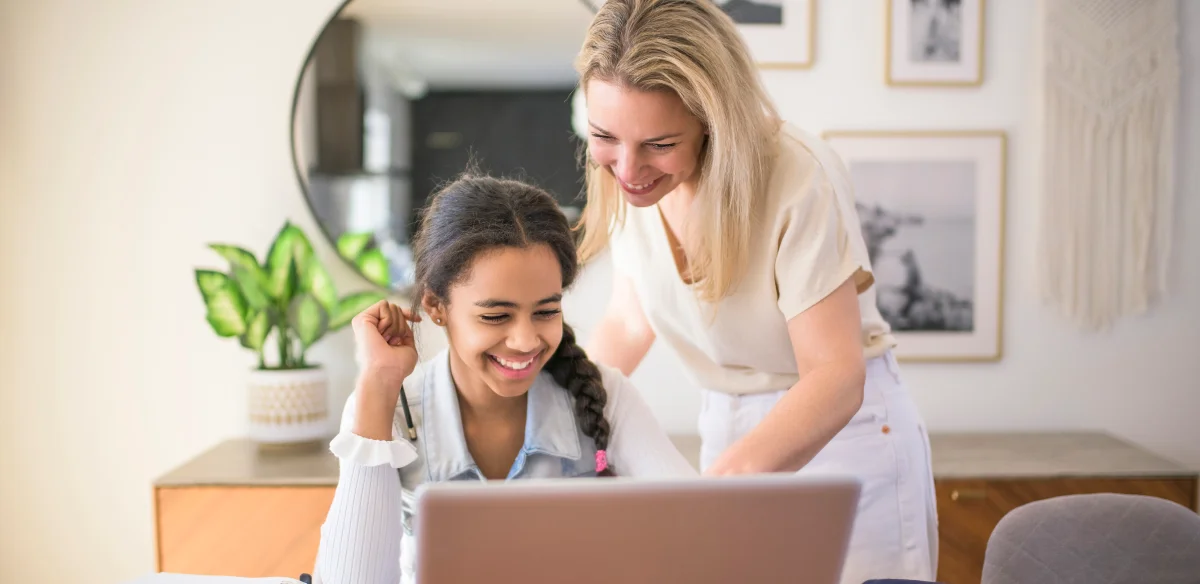 girl with her mom looking the computer